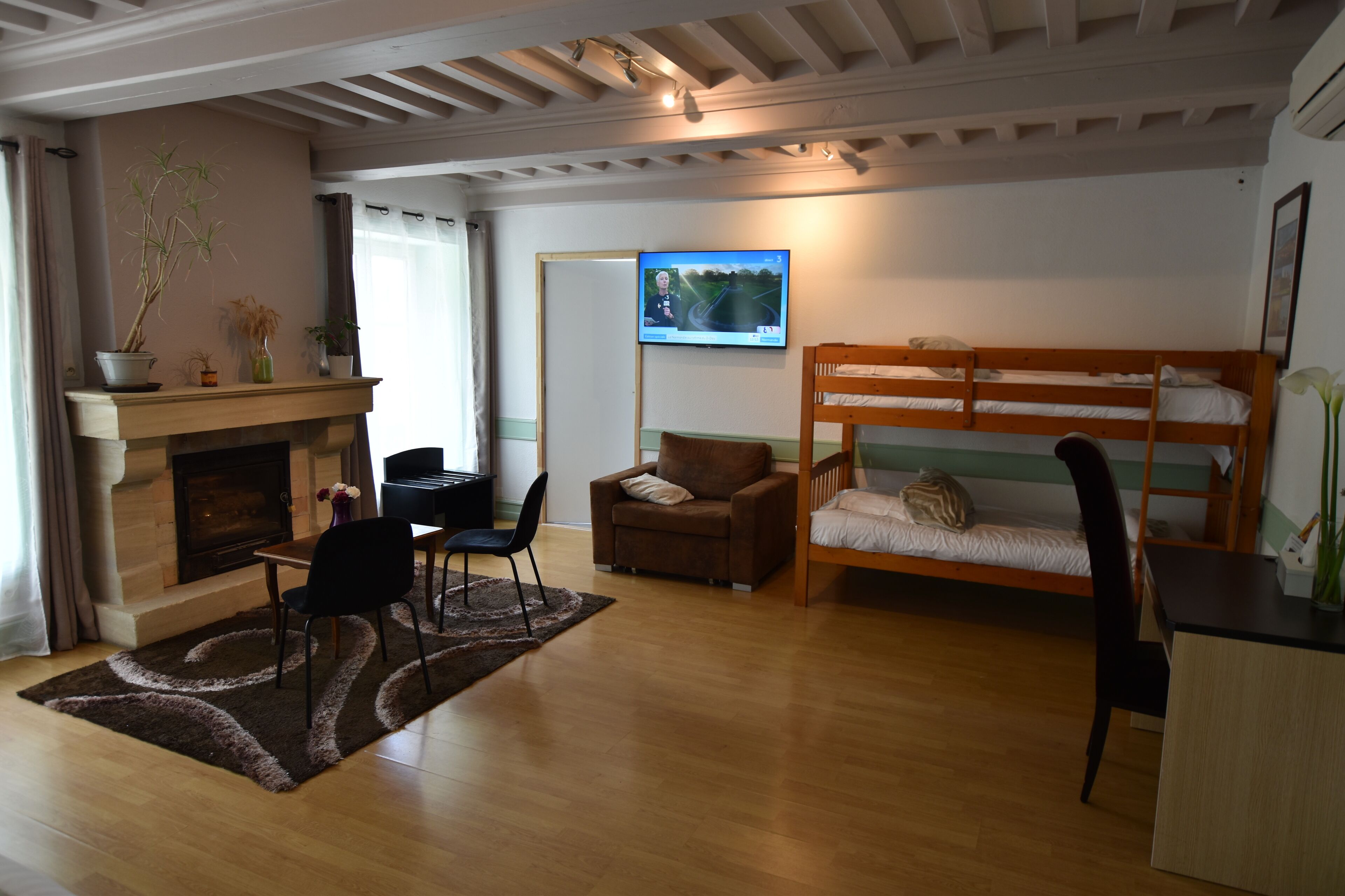 A cozy room with a fireplace, a sofa, a bunk bed, and a television.