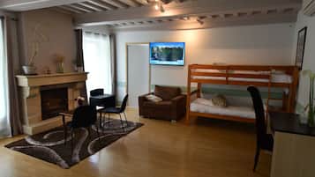 A cozy room with a fireplace, a sofa, a bunk bed, and a television.