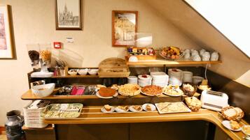 A buffet setup with various dishes and utensils.