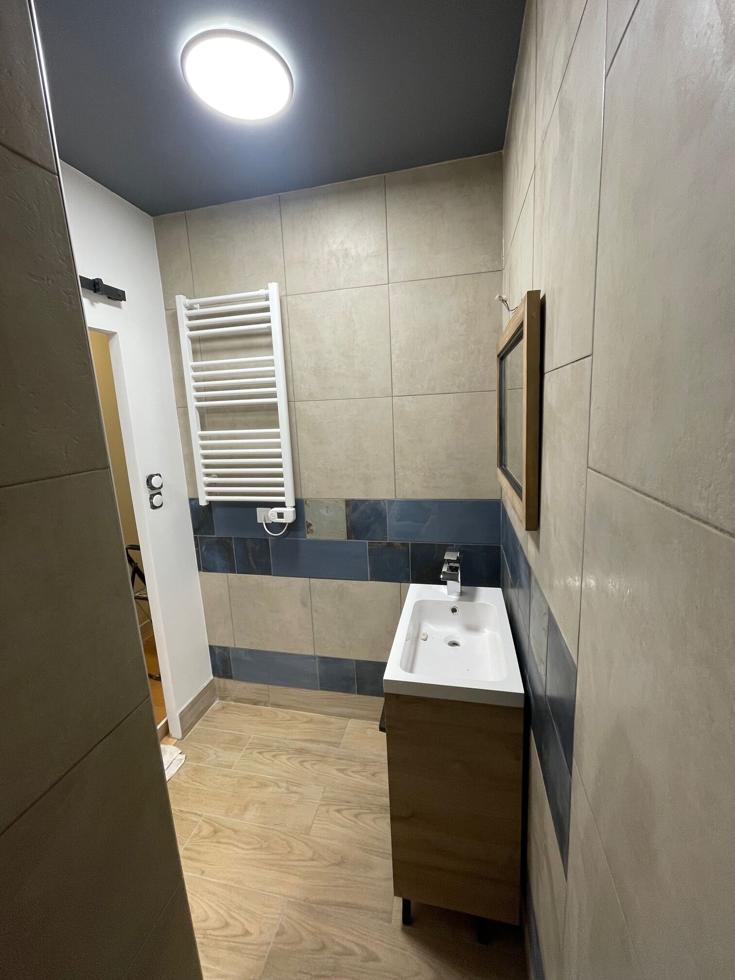 A bathroom with a white sink, a mirror, and a towel rack.