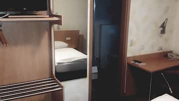 A hotel room with a bed, a desk, a television, and a wardrobe.