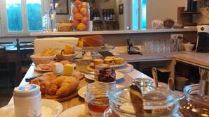 Un buffet de petit-déjeuner proposant une variété d'aliments, notamment des viennoiseries, des fruits et des condiments.