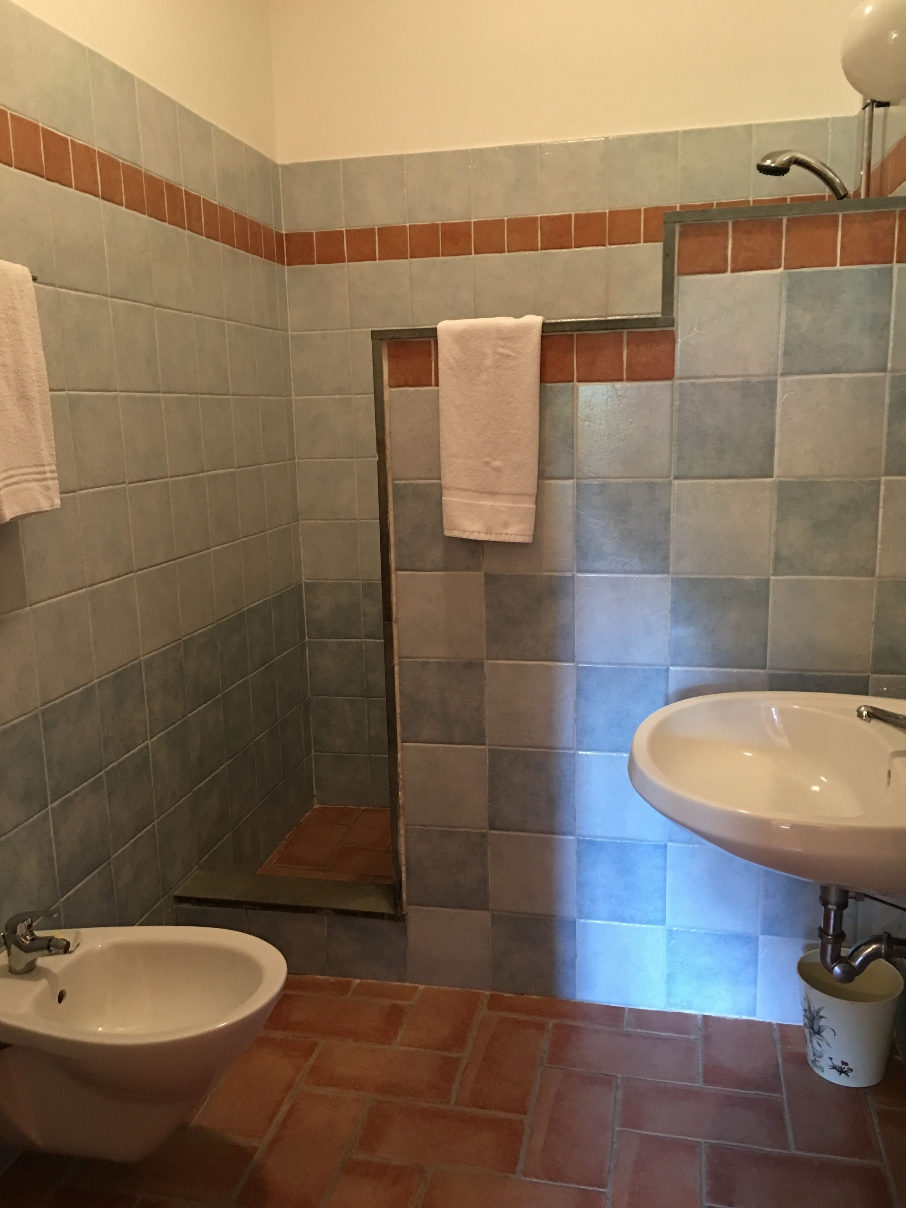 Un baño con bidé, lavamanos y un perchero para toallas.