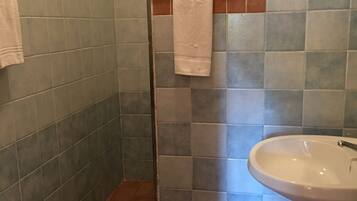 Un baño con bidé, lavamanos y un perchero para toallas.