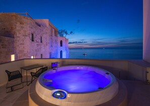 Un jacuzzi con vista al mar al atardecer.
