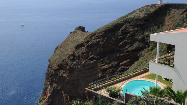 Ein Anwesen am Felsen mit Pool, Leuchtturm und Meerblick.