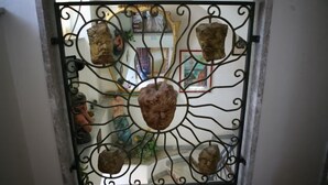 Una ventana con una reja metálica que presenta varios elementos escultóricos.