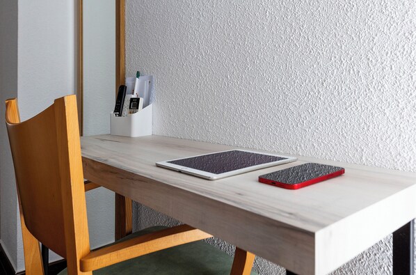 A wooden table with a tablet and a smartphone on it. - Hotel Bersoca (Benicassim)