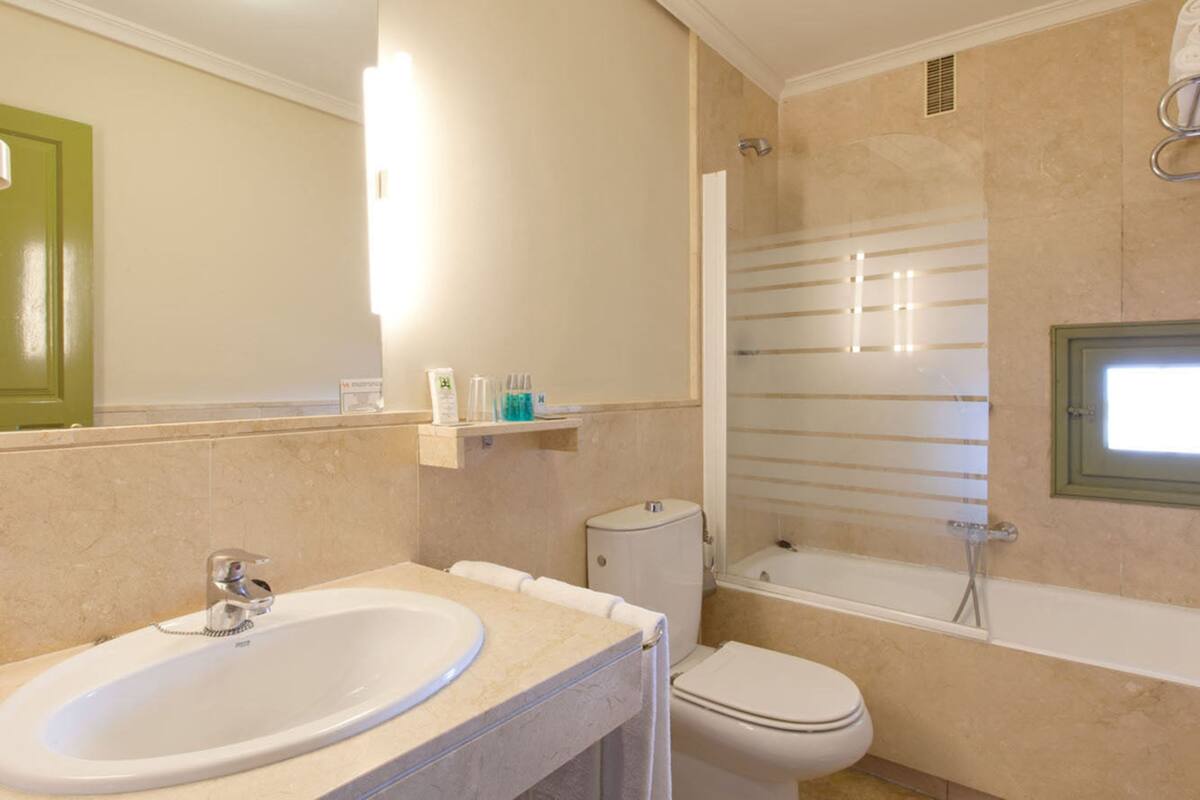 Un baño con lavamanos, inodoro y bañera.