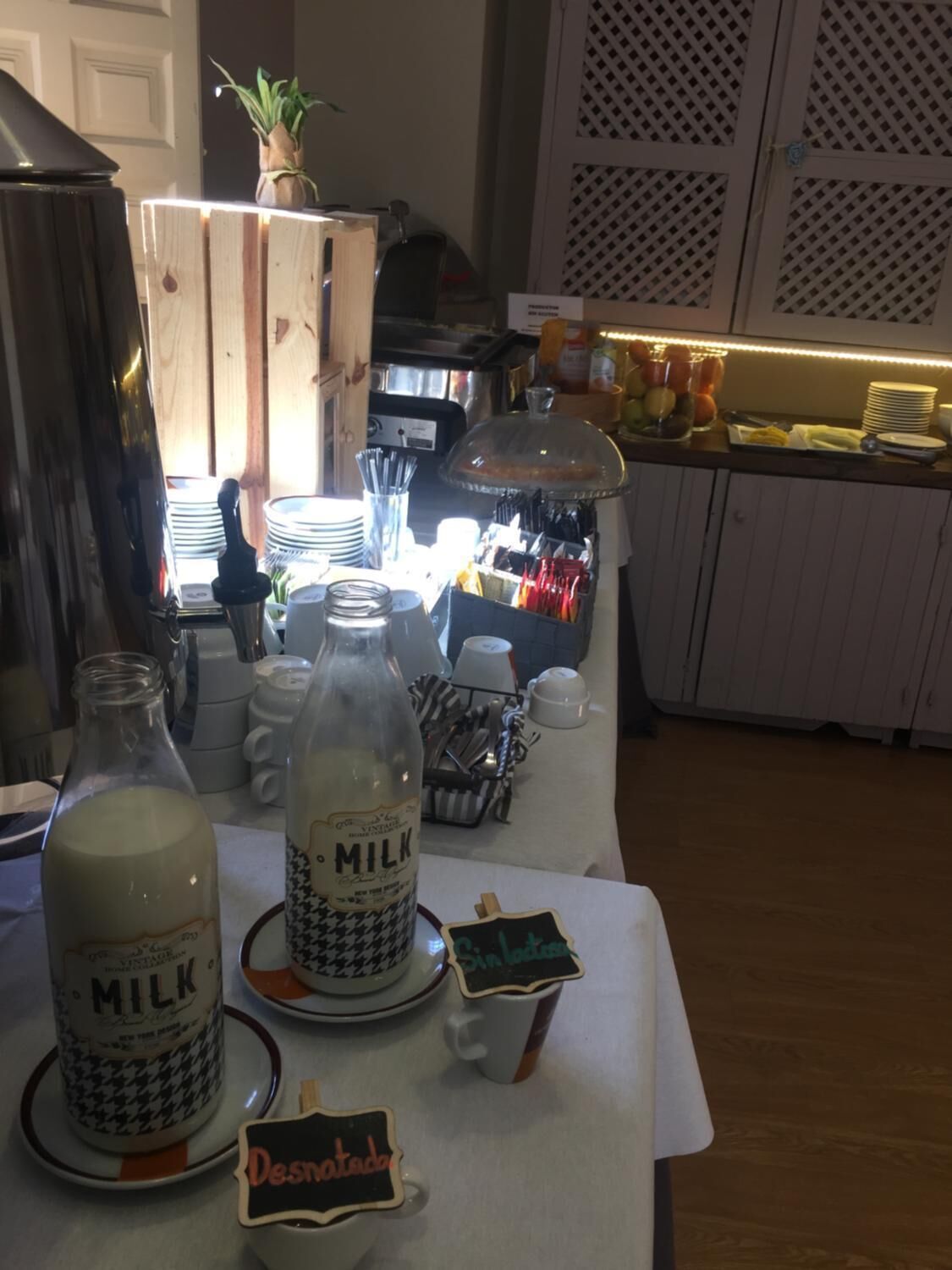 Ein Frühstücksbuffet mit Milchflaschen, Tellern und Besteck.