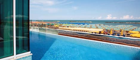 Piscine extérieure, parasols de plage, chaises longues