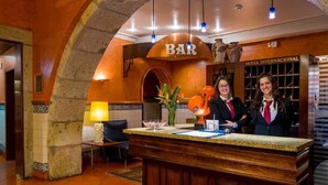 A reception area with a bar sign, a reception desk, and a decorative vase. - Hotel Internacional (Porto)