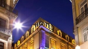 A hotel with a classic architectural style, featuring a prominent entrance and illuminated signage. - Hotel Internacional (Porto)