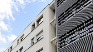 Ein mehrstöckiges Gebäude mit moderner Fassade, das eine Reihe von Fenstern und ein auffälliges Schild für Séjours & Affaires zeigt.