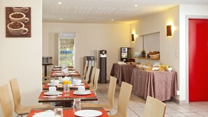 Ein Hotelrestaurant mit mehreren Tischen, Stühlen, einer Kaffeemaschine und einem Kühlschrank.