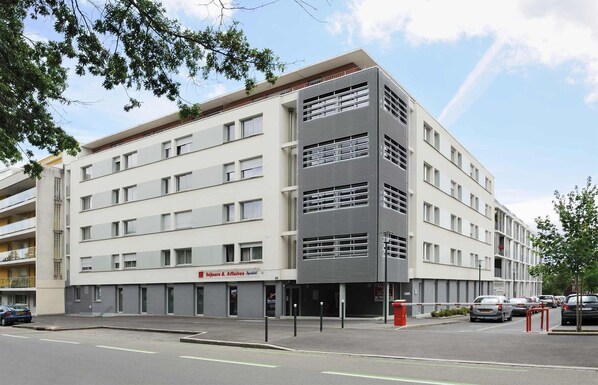 A multi-story hotel with a modern design, featuring a prominent slatted facade on one side.