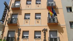 A hotel named "HOTEL MOLINO" with balconies and flags.