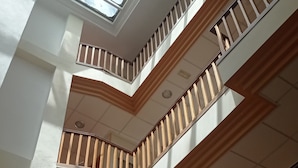 A multi-level interior with a skylight, wooden railings, and a sign indicating a smoking area.