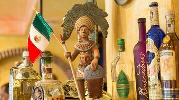 A collection of liquor bottles and a figurine on a shelf.
