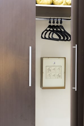 A wardrobe with a hanging rack and a framed picture on the door. - Aguas do Iguacu Hotel (Foz do Iguaçu)