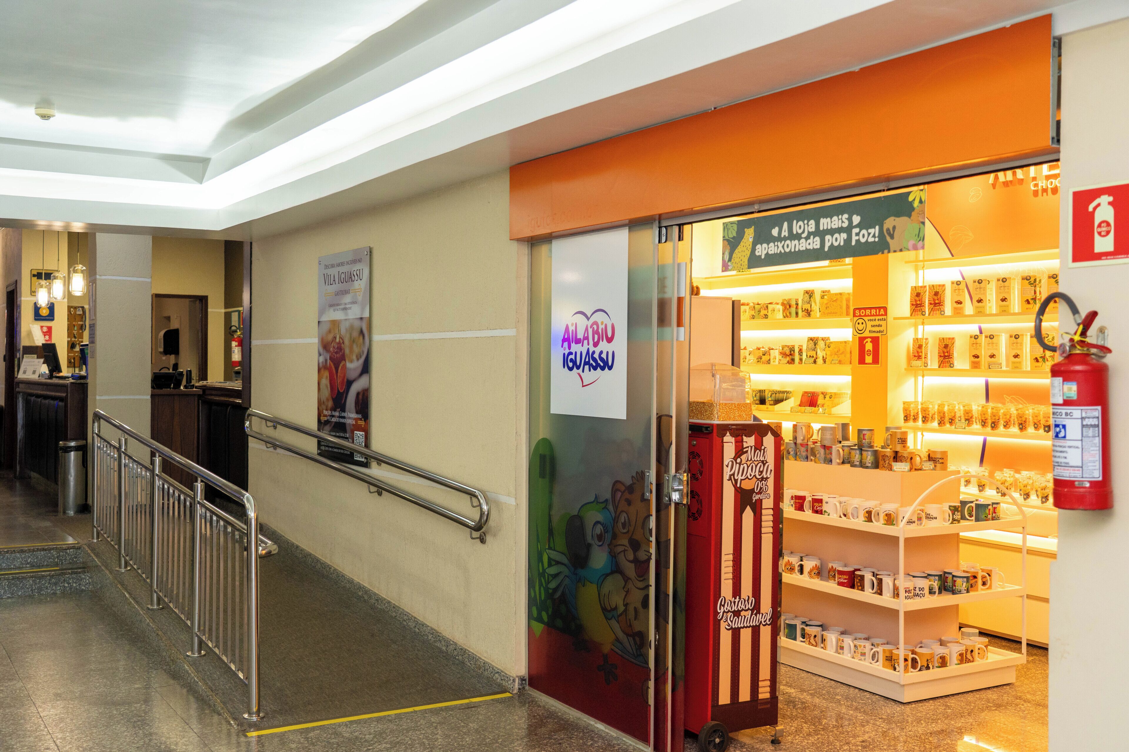 A corridor with a store featuring a sign for 'Alabio Iguassu' and a display of mugs.