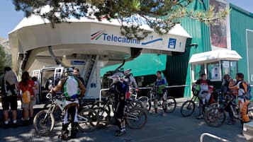 Un grupo de ciclistas reunidos cerca de un edificio con un letrero que dice 'Telecabina'.