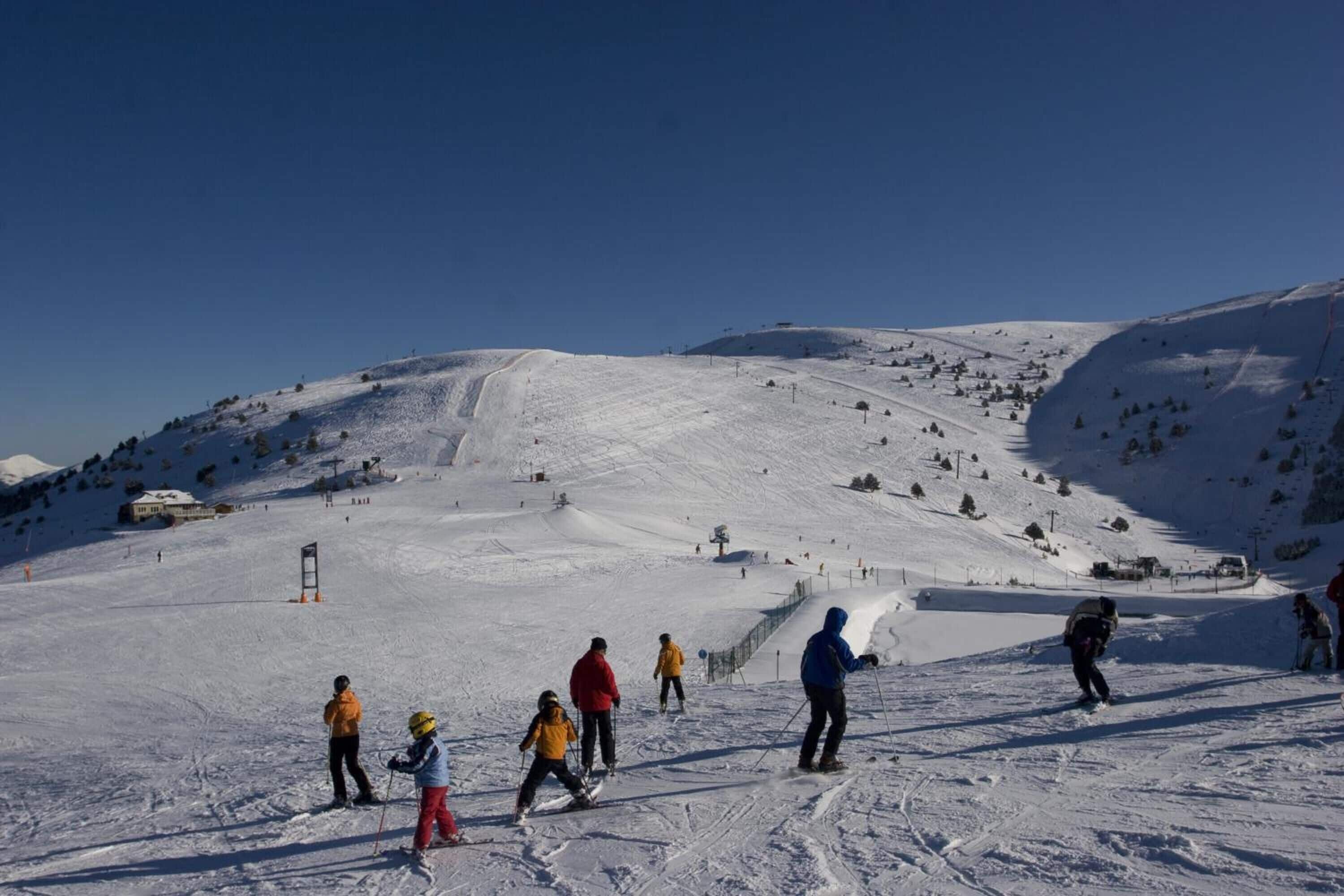 Pista nevada para esquiar con esquiadores y snowboarders.
