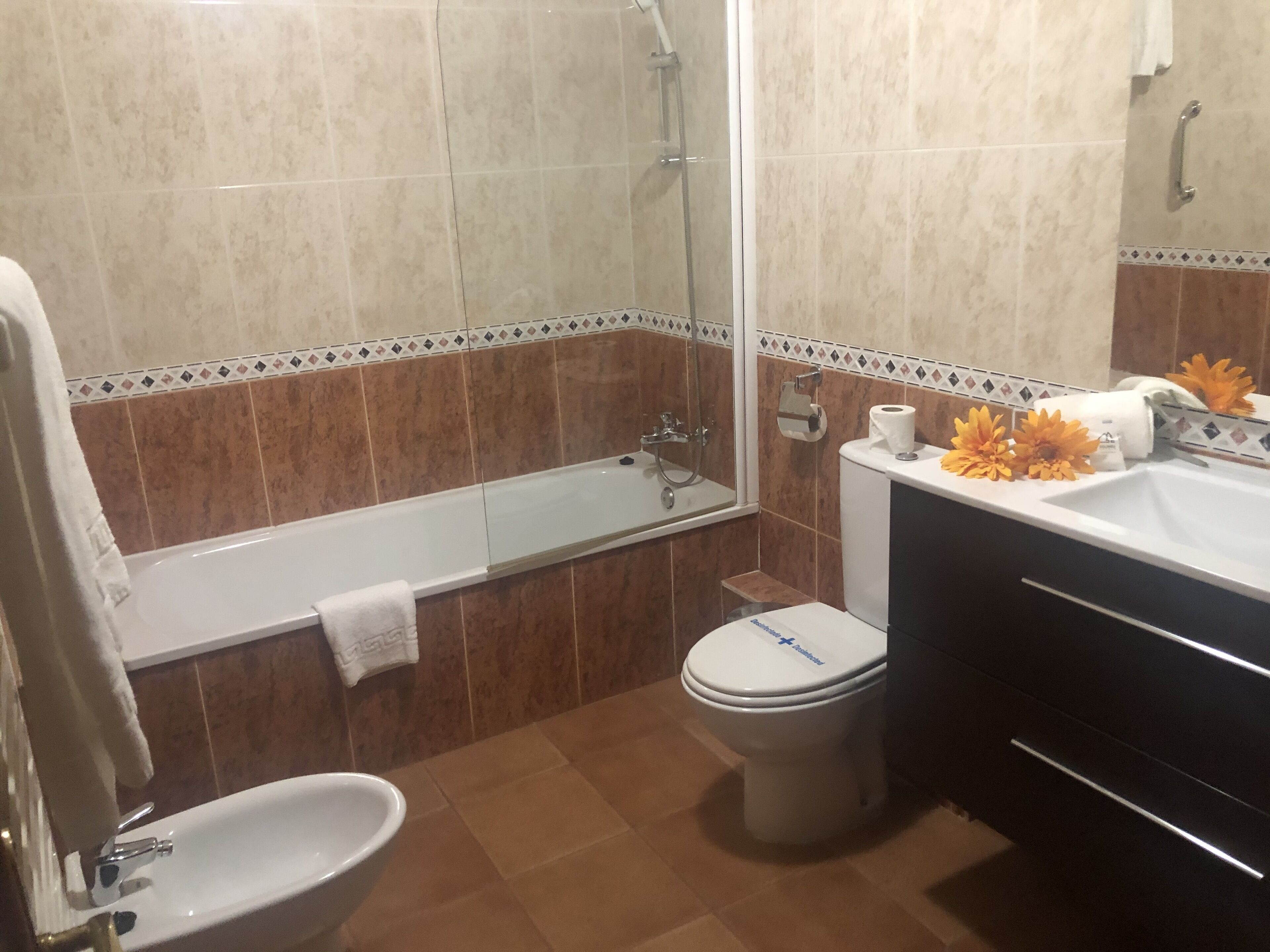 A bathroom with a bathtub, toilet, sink, and a shower.
