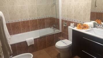A bathroom with a bathtub, toilet, sink, and a shower.