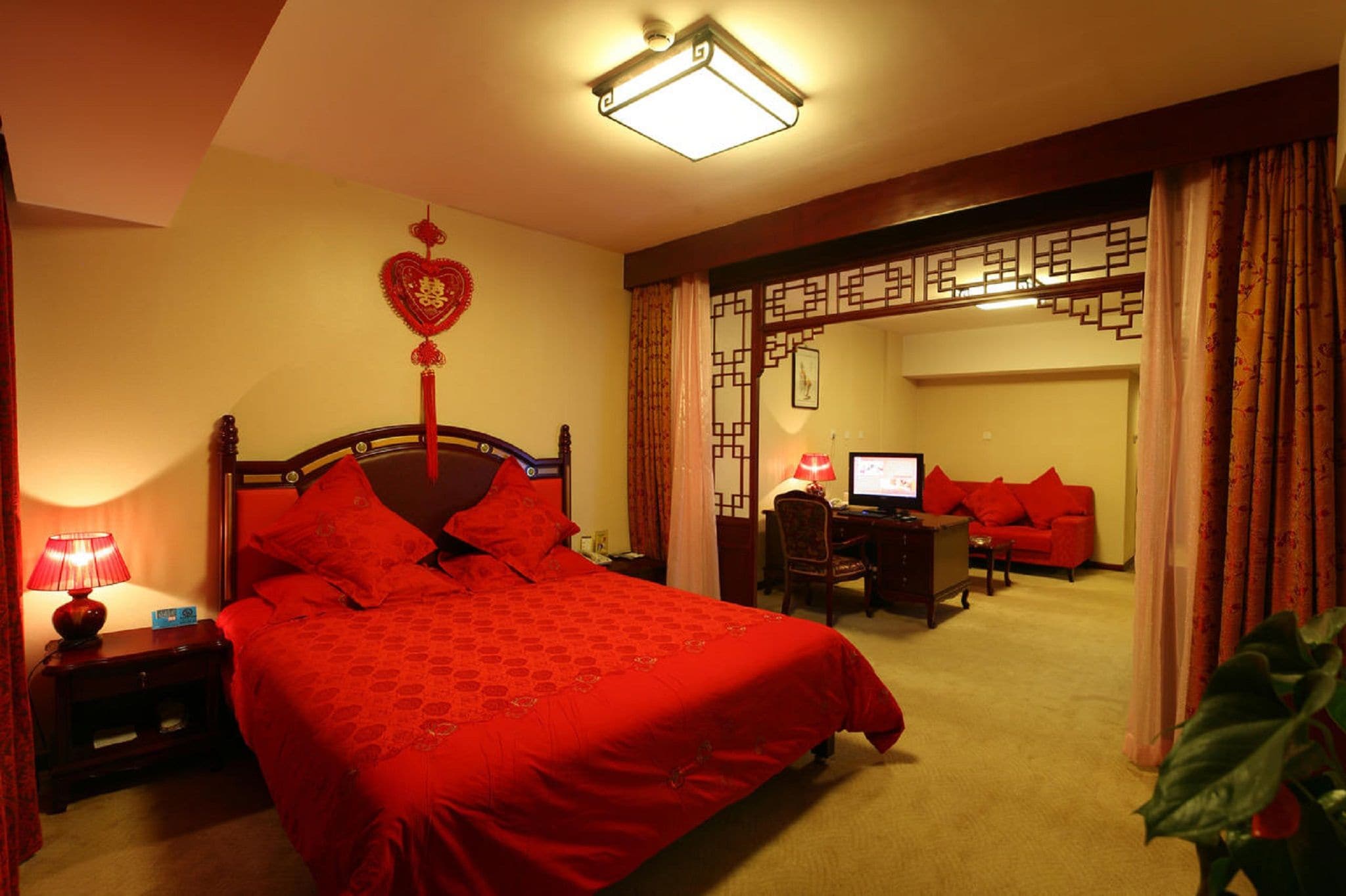 Une chambre d’hôtel avec un grand lit, un bureau avec un ordinateur et une télévision.
