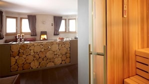 Una habitación acogedora con chimenea, pared de troncos y un banco de madera.