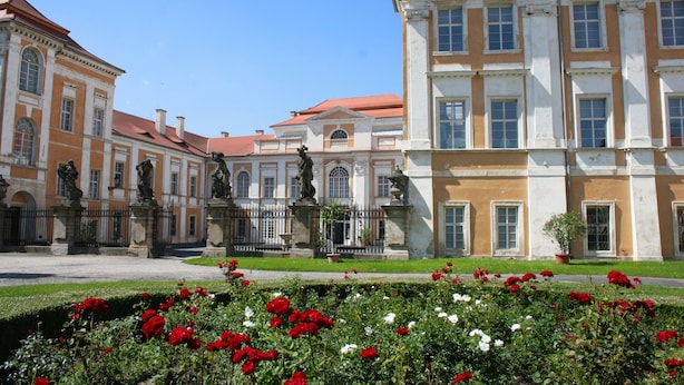 A historic building with classical architecture, featuring symmetrical windows and a central statue. - Hotel Casanova (Duchcov)