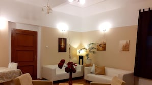 A cozy room with two sofas, a small table, and a door. - Hotel Casanova (Duchcov)