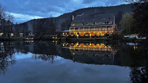 A lakeside hotel with a reflection in the water, featuring a large building with multiple windows and a balcony. - Hôtel du Lac (Guebwiller)