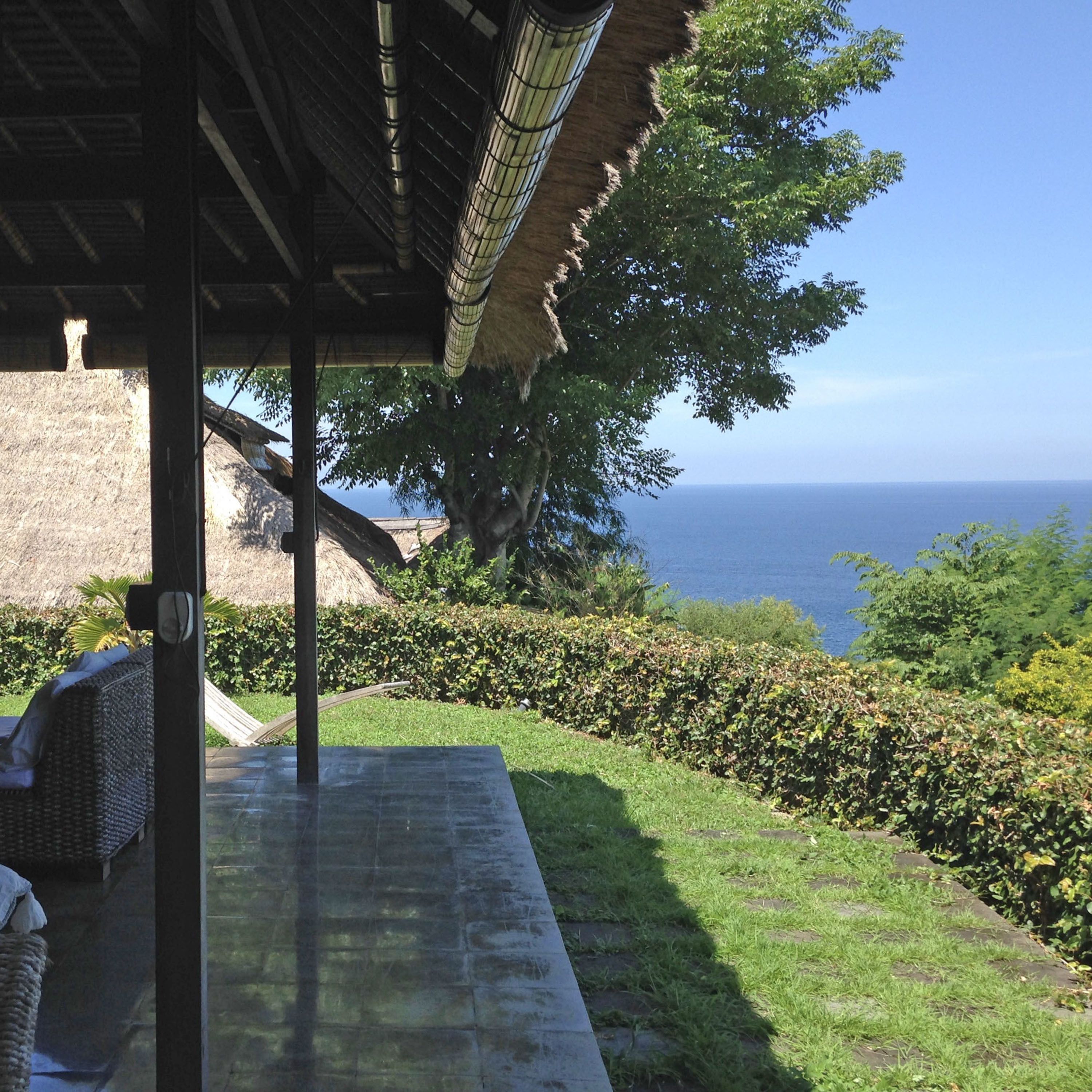 A covered outdoor area with a view of the sea.