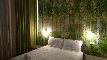 Relax in a serene space with a large bed, green curtain, and a forest mural.