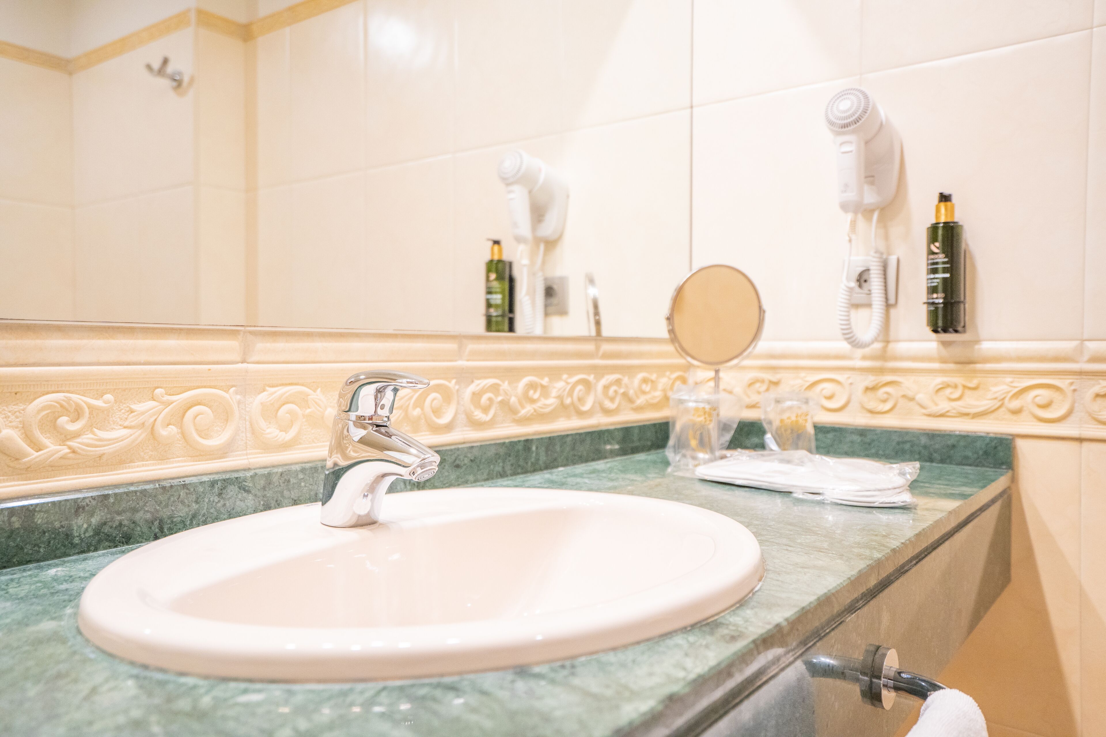 Un baño con lavabo, espejo y secador de pelo.
