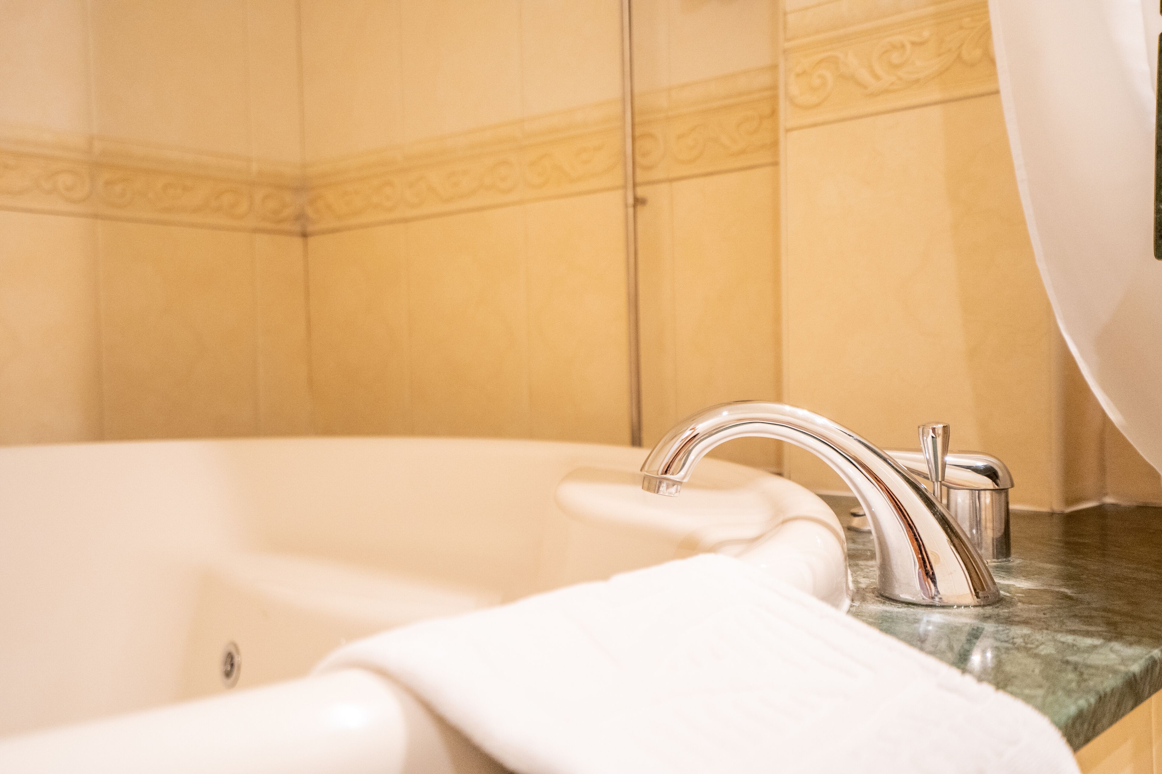 A bathroom with a bathtub, a sink, and a mirror.