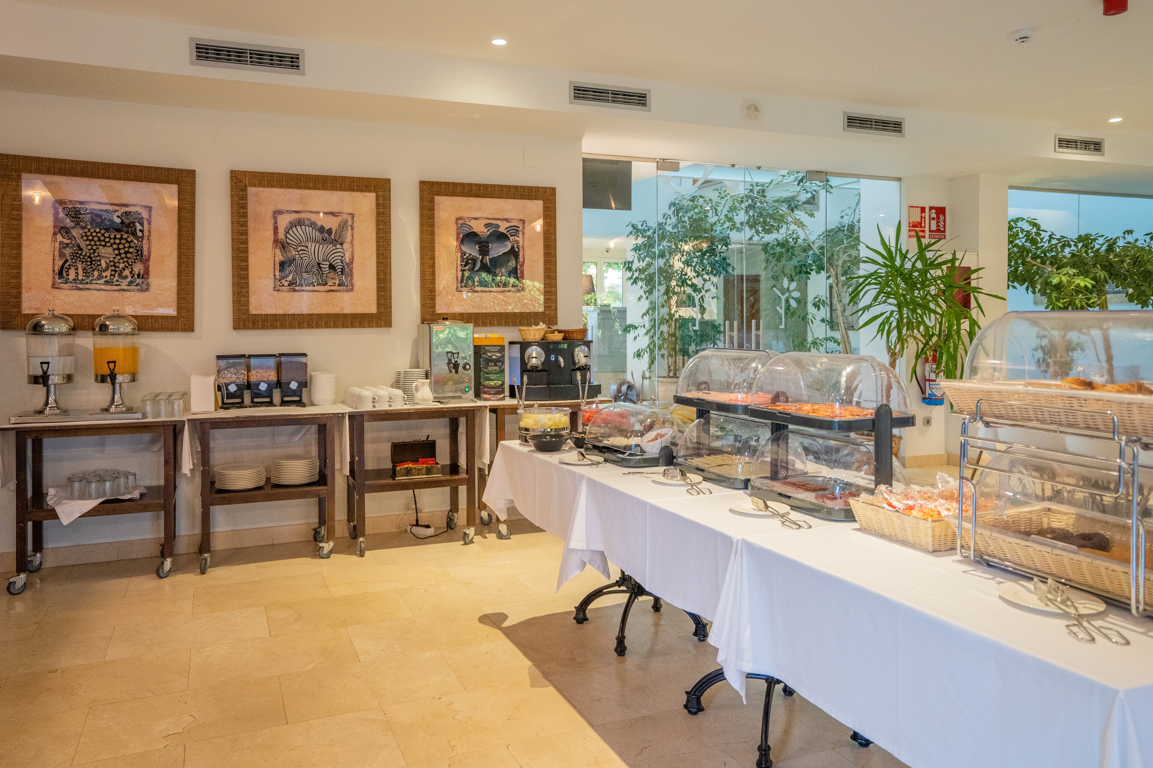 A buffet setup with food display cases, serving trays, and a white tablecloth.