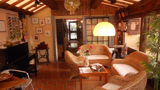 A cozy living room with wicker furniture, a television, and a dining area with a tiled floor.