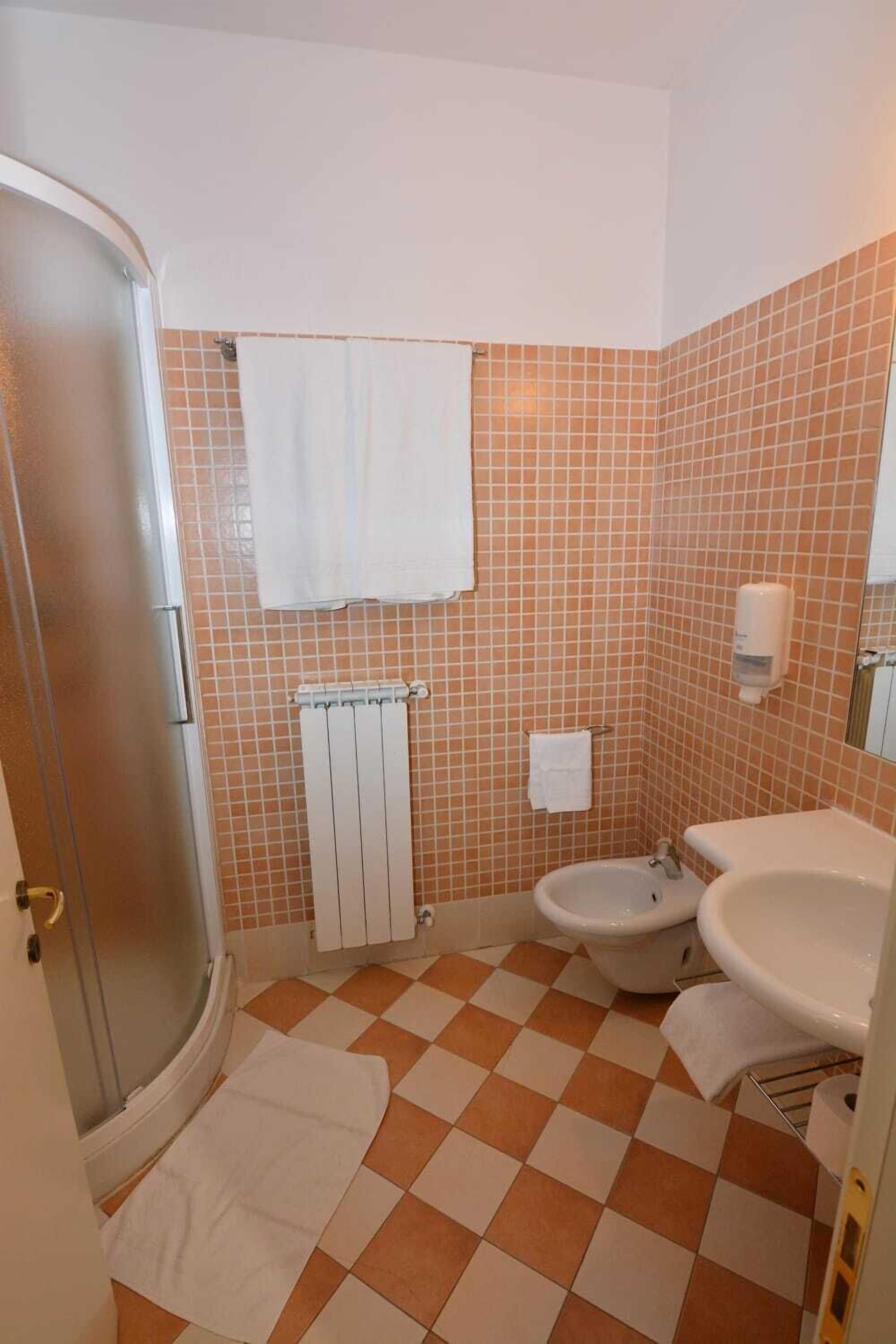 A bathroom with a shower, toilet, and sink.