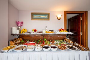 Ein Buffet mit verschiedenen Frühstücksangeboten, darunter Obst, Gemüse und Gebäck.