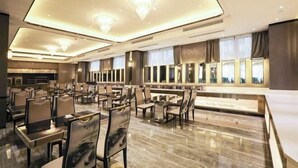 A spacious hotel lobby with a high ceiling, modern chandeliers, and a large seating area with tables and chairs. - Rebecca Hotel (Zhengzhou)