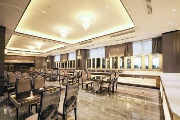 A spacious hotel lobby with a high ceiling, modern chandeliers, and a large seating area with tables and chairs. - Rebecca Hotel (Zhengzhou)