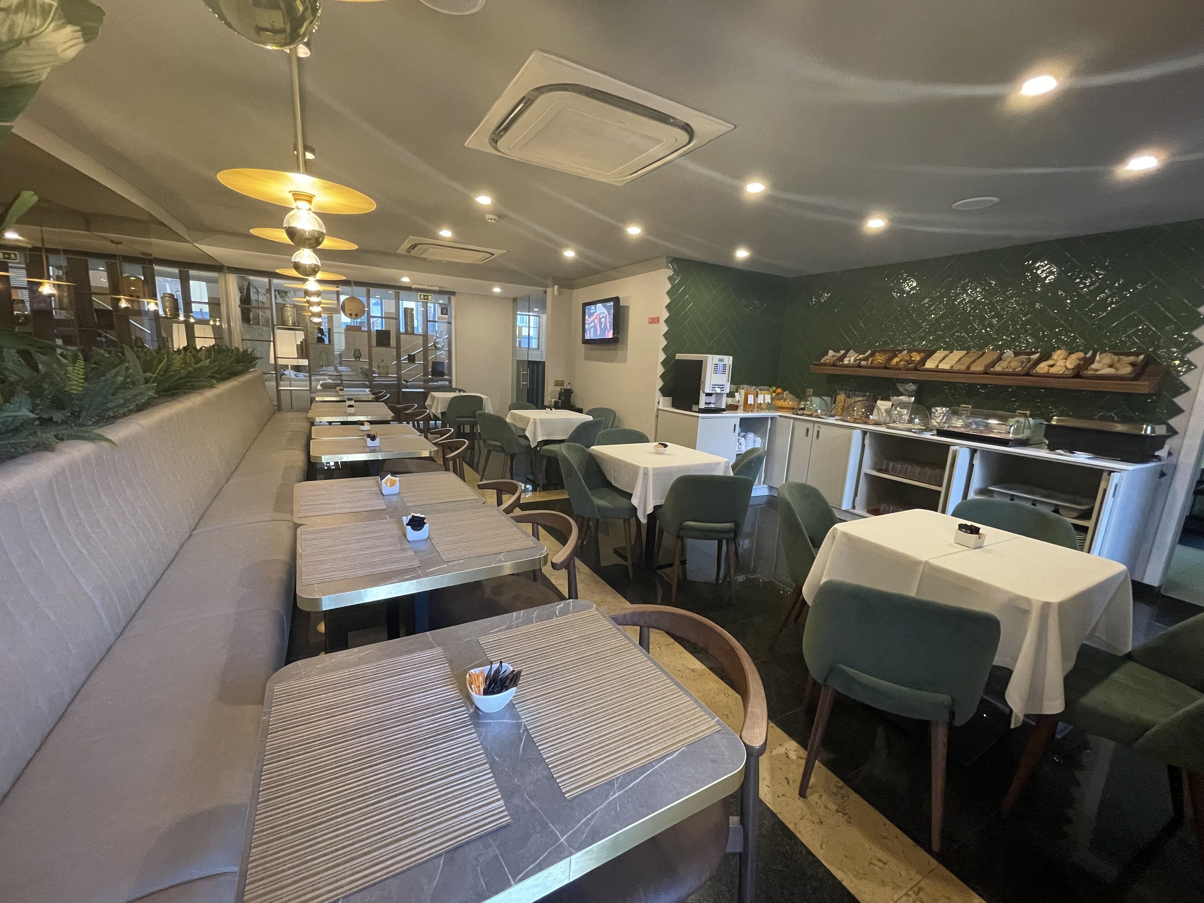 Un interior de restaurante con cabinas, mesas y una barra.