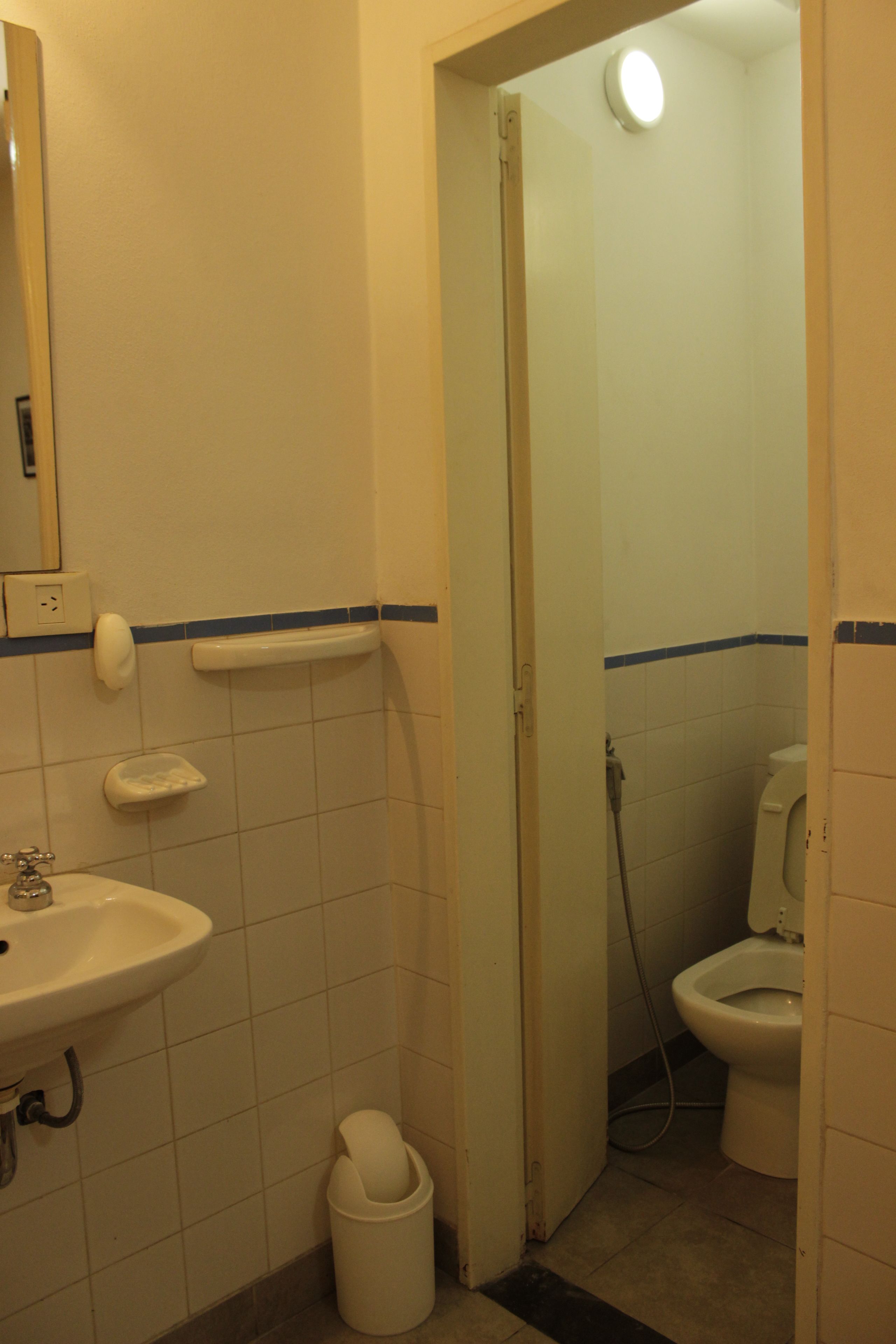 A bathroom with a sink, toilet, and shower area.