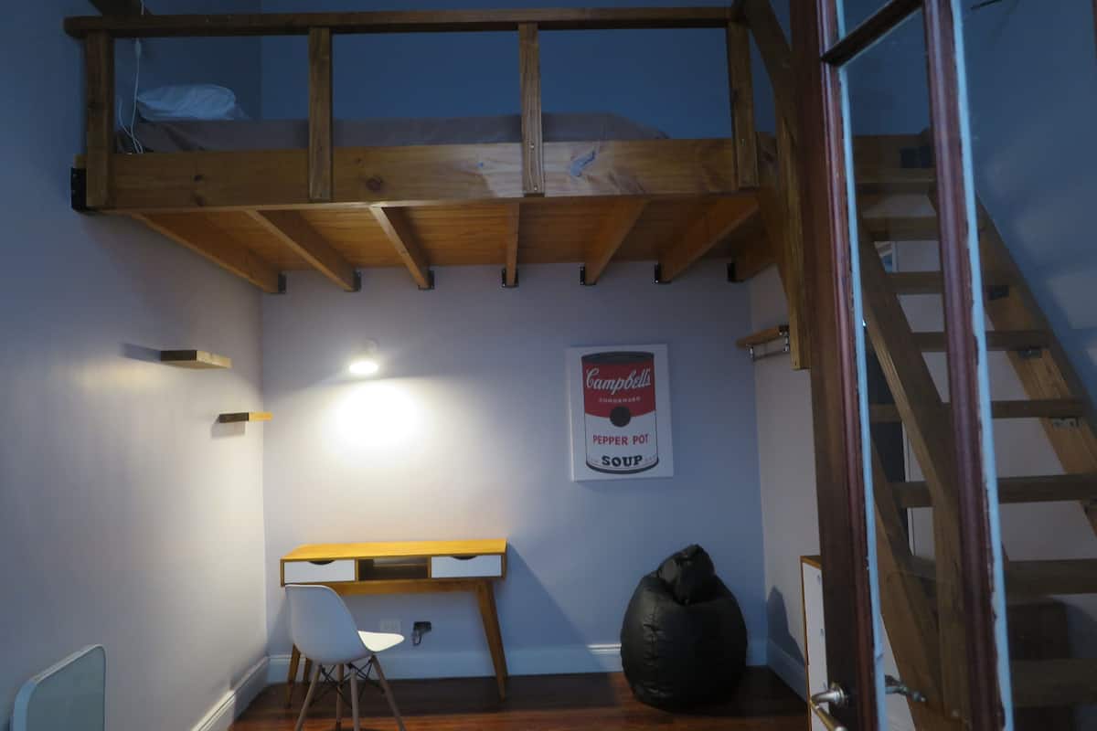 Ein kleines Zimmer mit Schlafkoje, Schreibtisch und Sitzsack.