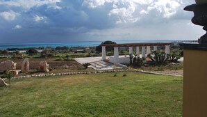 A landscaped garden with a gazebo, a clear view of the sea, and a distant shoreline. - La Rosa dei Venti (Portopalo di Capo Passero)