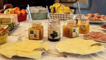 Ein reichhaltiges Buffet mit Käse, Obst und verschiedenen Beilagen.