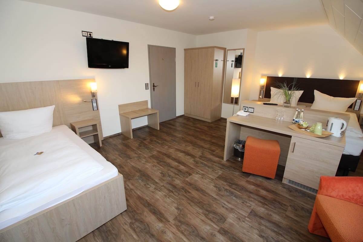Habitación de hotel con cama, escritorio y kitchenette.